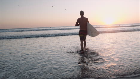 Surfista-Corriendo-Hacia-El-Agua-Al-Atardecer-Sigue-Cam-Nicaragua-Beach
