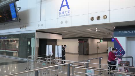 A-passenger-wearing-a-face-mask-arrives-at-Chek-Lap-Kok-International-Airport-arrival-hall-in-Hong-Kong,-China