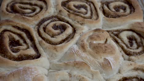 Sliding-overhead-view-of-freshly-baked-cinnamon-rolls-hot-from-the-oven