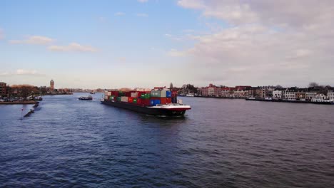 Aerial-View-Of-Salute-Cargo-Ship-Making-Its-Way-Along-Oude-Maas-Through-Dordrecht