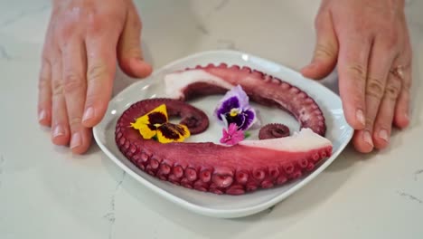Slow-motion-footage-of-a-plate-of-octopus-tentacles-being-gently-set-on-a-table