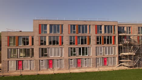 Sideways-aerial-movement-around-new-exterior-facade-of-construction-site-in-Zutphen-of-real-estate-investment-and-social-housing-market-collective-building