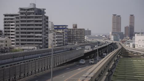 Fondo-Urbano-De-Osaka,-Vía-De-Monorraíl-Y-Autopista-Con-Apartamentos,-Japón