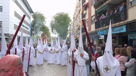 Penitents-march-during-a-procession-as-they-celebrate-Holy-Week-in-Seville,-Spain