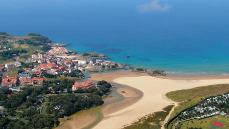 Aerial-drone-view-of-summertime-holiday-coastline-in-Cantabria-Island,-pan,-day