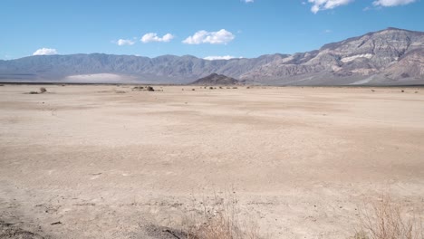 Valle-De-La-Muerte-En-El-Desierto-De-Mojave,-California-Con-Pastos-Y-Piedras,-Muñeca-Aérea-En-Tiro