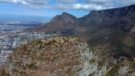 Drone-shot-of-Lions-Head-in-Cape-Town---it-is-circling-around-the-top-of-Lions-Head,-facing-Table-Mountain-and-city-center