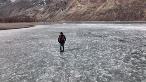 Adult-Male-Walking-Across-Frozen-Khalti-Lake