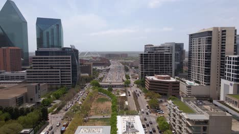 Aerial-view-over-the-city-parks-and-towards-the-freeway,-in-sunny-Dallas,-Texas,-USA