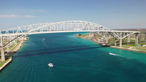 Blue-Water-Bridge-connecting-Port-Huron,-Michigan-USA-and-Sarnia,-Ontario-Canada-with-drone-moving-forward