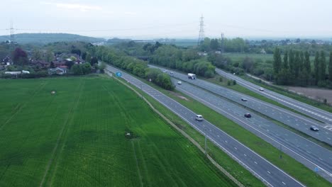 Aerial-descending-view-above-morning-traffic-vehicles-driving-on-busy-UK-motorway-M62-lanes