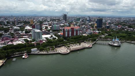 aerial-view-of-Makassar-city-Sulawesi-Indonesia-on-a-sunny-day-along-the-water-with-a-mosque-in-the-distance