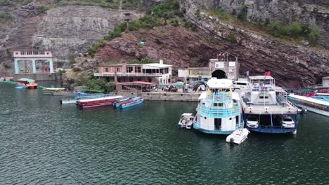 Ferry-Terminal-and-Boat-Service-at-Lake-Koman,-Albania---Circle-Pan-Shot