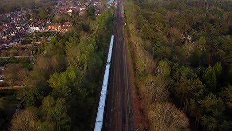 Aerial-view-train-travelling-through-English-countryside-on-sunny-day