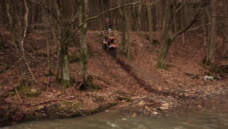 Motorbike-Shredding-Through-River,-Off-Road-Bike-Trial-splashing-water-and-mud,-Wild-Extreme-Sport,-Moto-Cross-biker-dangerous-adventure,-splash-dirty-rainforest-leaves