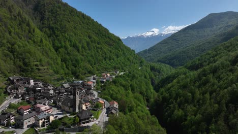 A-dynamic-rearward-moving-aerial-footage-of-the-towns-of-Villadossola,-Domodossola,-and-Simplon-pass