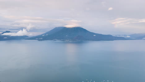 Luftschwenk-Nach-Oben-Hyperlapse-Von-Bergen-Jenseits-Des-Atitlan-Sees-In-Guatemala
