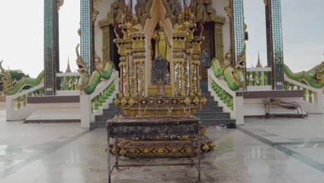 Details-Des-Thailändischen-Tempels-Dolly-Aus-Nächster-Nähe-Mit-Buddha-Statue-Und-Räucherstäbchen,-Die-Im-Freien-Stehen