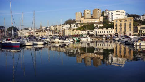 Torquay-inner-marina-with-the-town-and-boats-reflecting-in-the-harbor-water-at-golden-hour