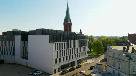 La-Iglesia-De-San-Andrés-Bobola-Detrás-De-Un-Edificio-De-Oficinas-Corporativas-En-Bydgoszcz,-Polonia
