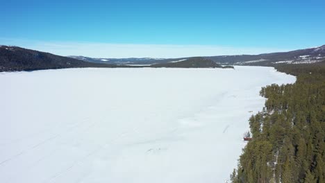 Volando-Sobre-El-Enorme-Lago-De-Agua-Dulce-Cubierto-De-Nieve-Tunhovdfjord-Mirando-Hacia-La-Isla-En-Palsbufjord-En-Nore-Y-Uvdal-Noruega---Revista-Natural-Utilizada-Para-Hidroelectricidad-Por-Statkraft-Noruega