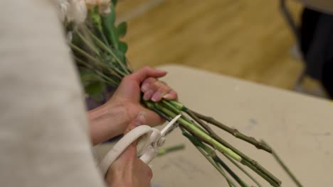 A-florist-clips-the-stems-of-flowers-in-a-bouquet-before-tying-them-together