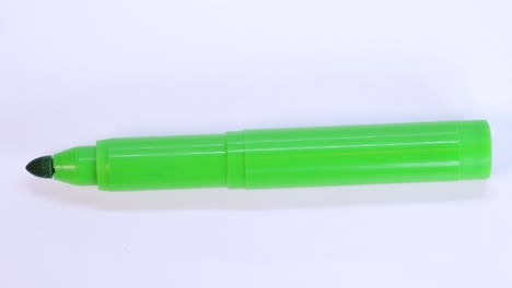 Grüner-Markierungsstift,-Der-Sich-über-Weißer-Hintergrundfläche-Dreht,-Makroaufnahme,-Nahaufnahme,-Detailansicht