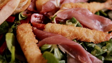 Salad-with-fried-shrimps,-parma-ham-and-cherry-tomatoes,-close-up
