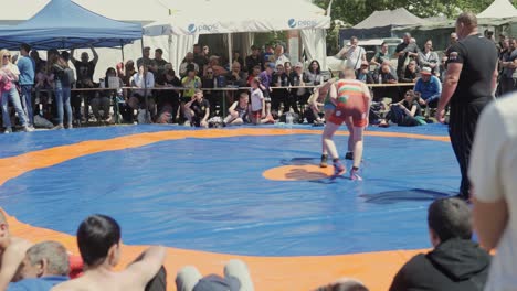 young-wrestlers-grapple-in-tournament-ring-watched-by-crowds-of-spectators