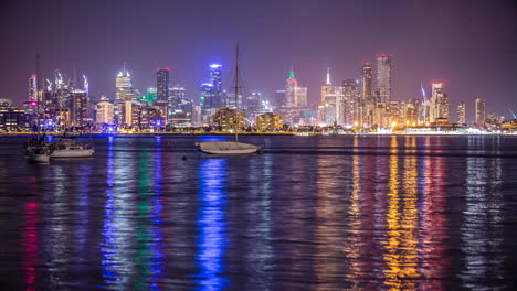 Melbourne-Australia-night-timelapse-over-water-with-colourful-reflections-looking-at-high-city-buildings-from-Williamstown