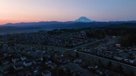 Wide-orbiting-aerial-of-a-Puyallup-neighborhood-nestled-under-the-looming-presence-of-Mount-Rainier-at-sunrise