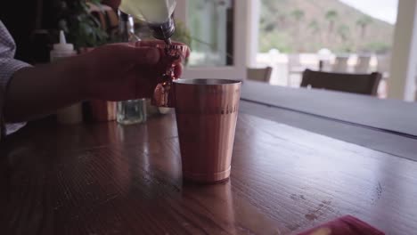 Slow-motion-footage-of-a-bartender-preparing-a-cocktail-drink-in-a-brown-cup