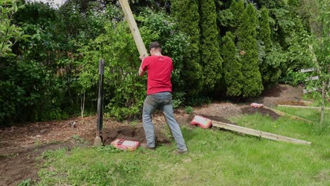 Setting-wooden-fence-pole-down-and-leveling-it-with-tool,-static-view