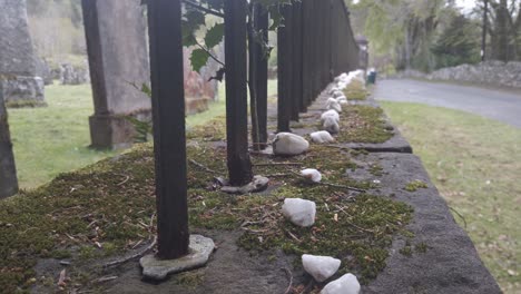A-row-of-white-stones-on-a-cemetery-wall