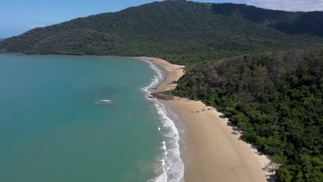 Bahía-De-La-Vaca-En-La-Selva-Tropical-De-Daintree-Antena-Hacia-Atrás-De-La-Playa-Y-La-Montaña,-Queensland,-Australia