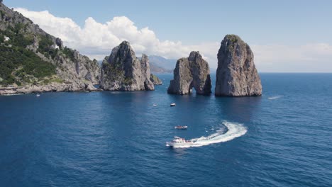 Barcos-De-Faraglioni-Famosos-Monumentos-Rocosos-Frente-A-La-Isla-De-Capri,-Italia---Antena