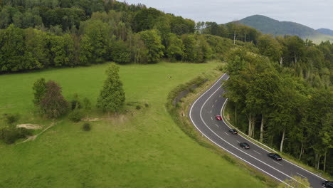 Fleet-of-sports-cars-driving-on-highway-in-mountains-of-Czechia,-drone
