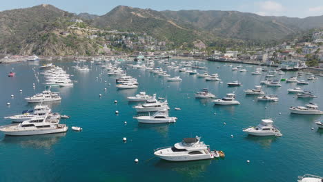 Aerial-Shot-Approaching-Boats-Anchored-on-Sparkling-Ocean-Water,-Drone-Perspective-of-Boats-in-Turquoise-Blue-Harbor-at-Catalina-Island