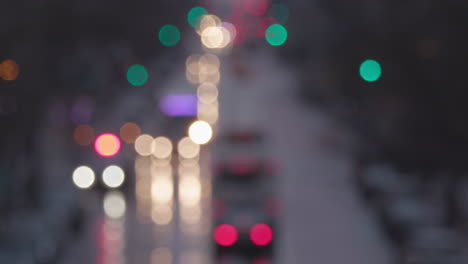 Blurred-slow-mo-of-a-wet-New-York-Manhattan-main-street-with-traffic,-out-of-focus-lights