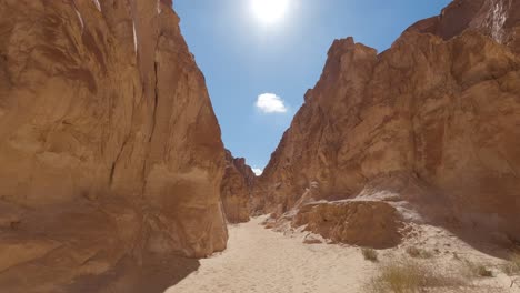 First-Person-View-Of-Sandy-Colored-Canyon,-South-Sinai,-Egypt,-Tilt-Shot-To-Sunny-Blue-Sky