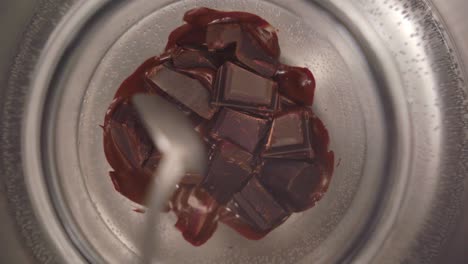 Close-up-view-of-a-person-mixing-chocolate-from-a-bowl-in-a-bain-marie