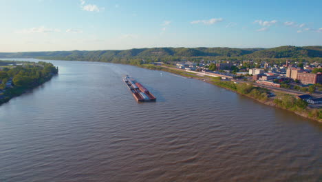 AERIAL---Barge-with-pusher-boat,-Ohio-River,-Ironton,-Ohio,-spinning-shot