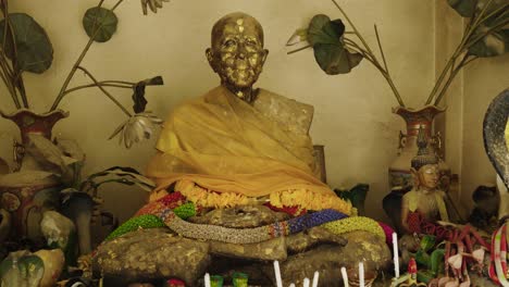 Statue-of-old-monk-with-snakes-and-lotus-flowers-in-a-Thai-Buddhist-temple