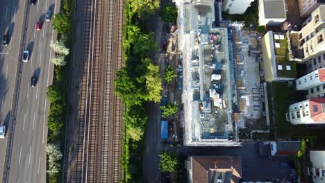 Cars-on-highway-train-station-Breathtaking-aerial-view-flight-drone-camera-pointing-down-tilt-up-drone-footage
of-Berlin-Friedenau-Summer