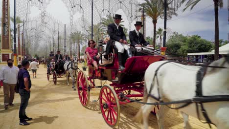 Horses-pull-carriages-of-people-enjoying-the-fair-in-Jerez-de-la-Frontera,-Spain