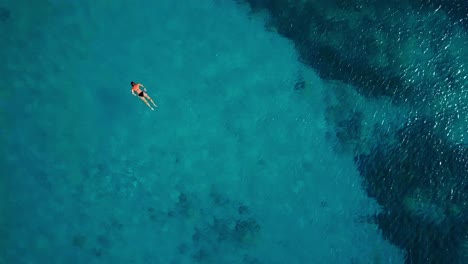 Overhead-view-of-a-woman-snorkeling-in-Westpunt,-Dutch-island-of-Curacao,-Caribbean-Sea
