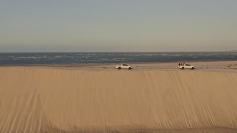 Offroad-trucks-explore-coastal-Brazil-desert-dune-top-in-sunset