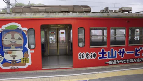 Omhi-Railway-Tanuki-Car,-with-Azuchi-sightseeing-ad-on-platform