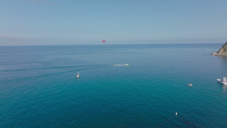 Flying-Over-Parasailing-Adventurer-in-Bright-Blue-Pacific-Ocean,-A-Sunny-Day-on-Catalina-Island