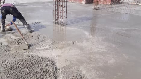 A-worker-Leveling-PCC-Foundation-Concrete-slab-On-A-New-Building-Construction-Site